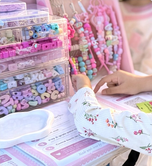 A little hand reaching for beads at the keychain display
