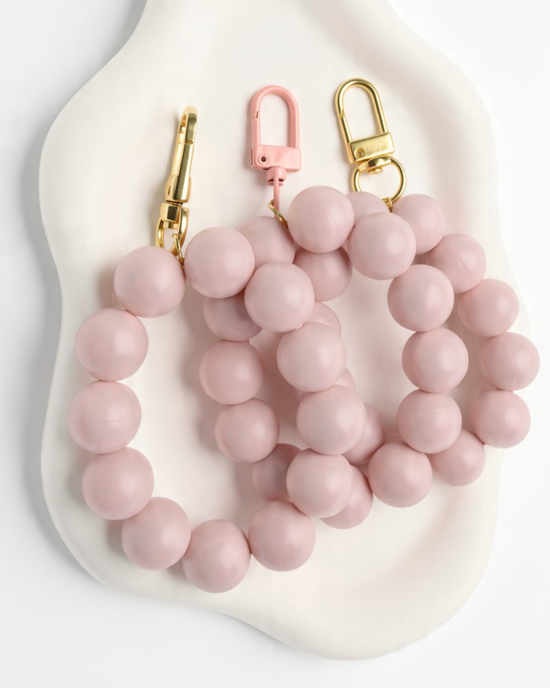 Three blush pink chunky silicone bead wristlets, two with gold clasps and one with a pink clasp