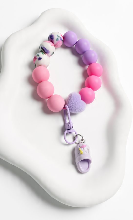 Pink and lavender silicone wristlet with a fuzzy heart and mini clog charm