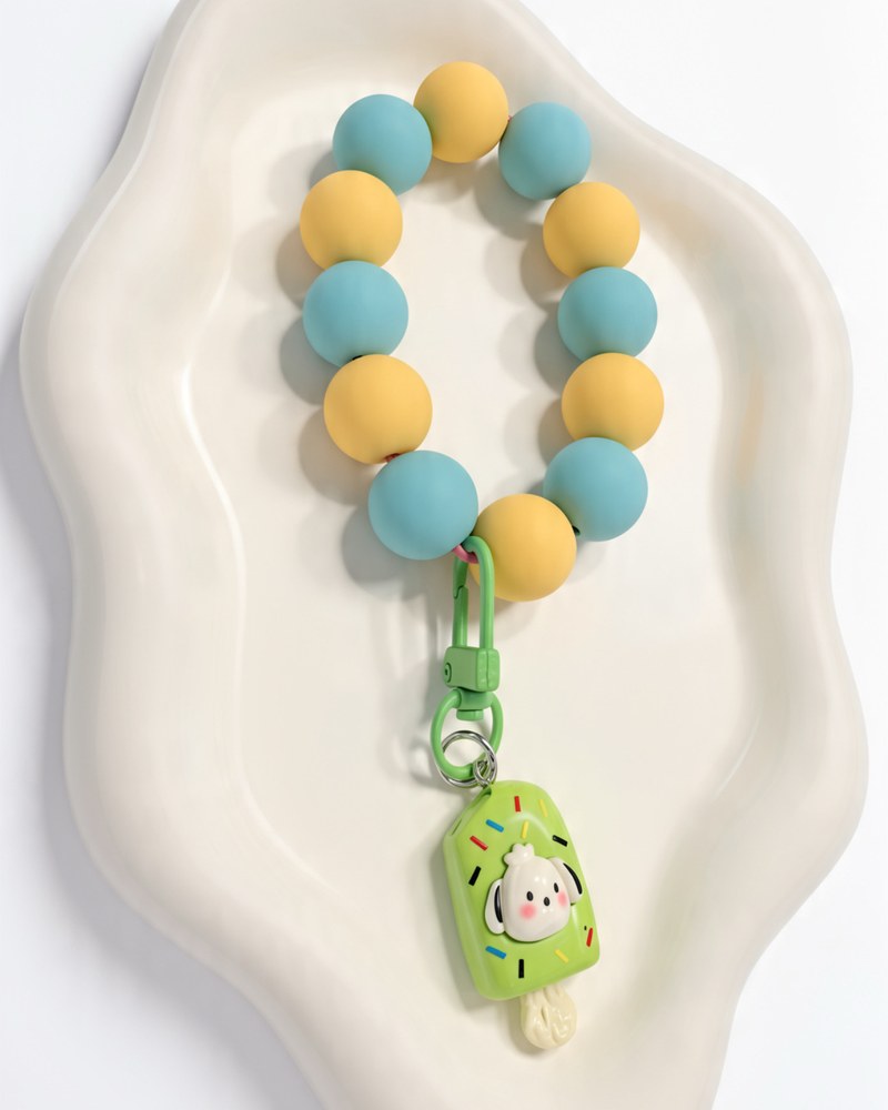 Teal and yellow silicone wristlet with a green ice pop charm