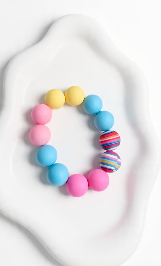 Blue, pink and yellow silicone bracelet with two striped beads